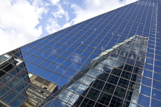 Reflection of buildings on a glass building in downtown regina