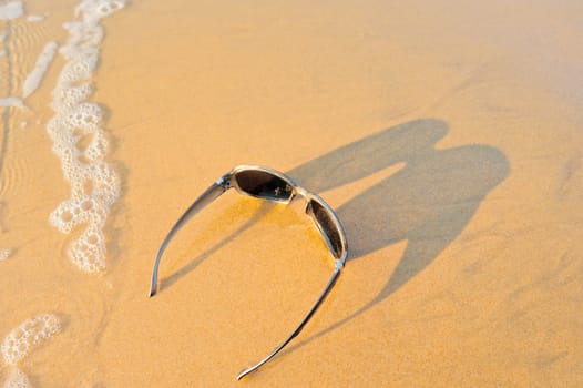 Sun glasses on the sandy sea shore