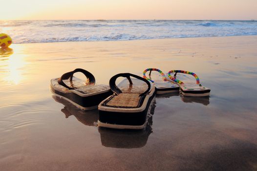 Beach sandals on the wet sandy shore