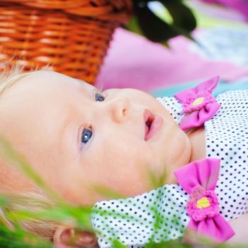 Closeup portrait beautiful little baby girl lying in the grass