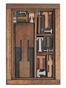 letter T abstract - vintage letterpress printing blocks of different size and style in a wooden box with dividers