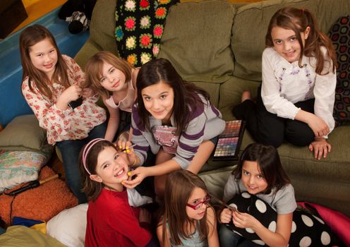 Group of little girls fixing hair and applying makeup