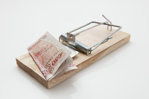 fifty pound note set on a mousetrap on white background