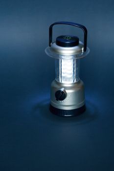 Luminous battery powered camping lamp on dark background