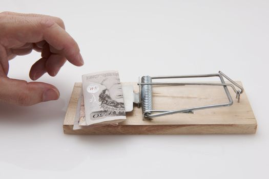 Male hand taking fifty pound note from mousetrap