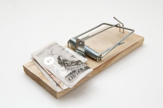 fifty pound note set on a mousetrap on white background