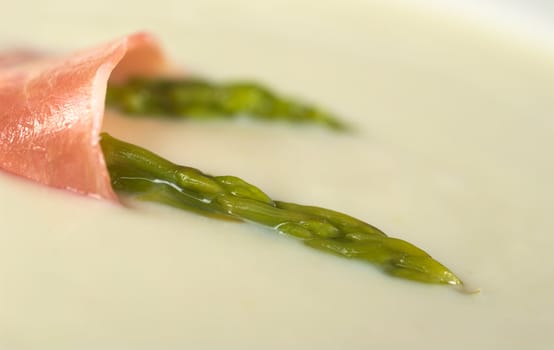 Green asparagus and ham garnishing cream of asparagus (Very Shallow Depth of Field, Focus is through the front green asparagus)