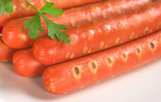 Sausages garnished with a parsley leaf (Selective Focus, Focus on the front of the sausages)