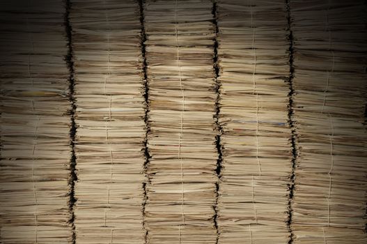 Five uniform piles of newspapers to be recycled lit from above