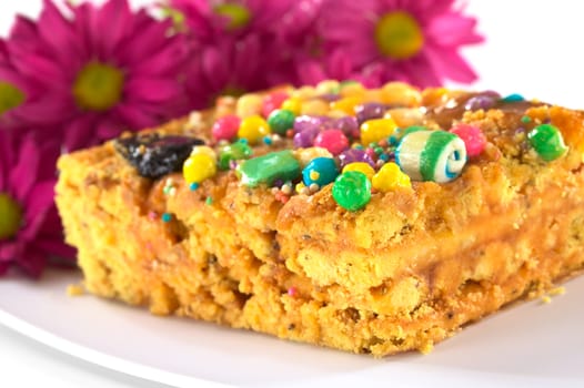 Peruvian colorful cake called Turron flavored with anis, sesame, dried fruits and honey and garnished with colorful sweets on top (Selective Focus, Focus on the front tip and the green ball on top)