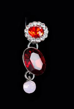 Beautiful earring with colorful red gems on black background