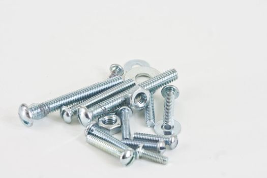 Assorted nuts and bolts with washers on a white background.
