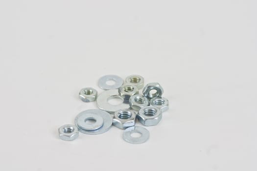 A pile of assorted nuts and washers on a white background.