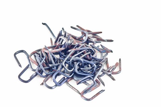 A pile of U shaped wire staples on a white background.