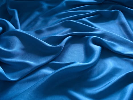 abstract blue silk background, cloth is bedded by waves