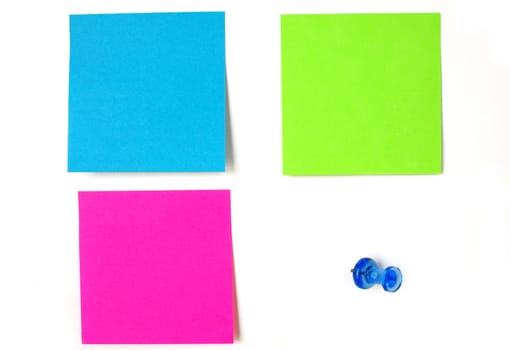 Three colorful and blank sticky notes with a blue stick pin isolated on a white background.