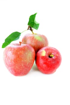 Three apples and one with leaves isolated on a white background.