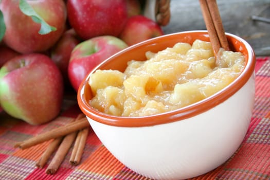 A bowl of fried/stewed apples with fresh apples in the background.