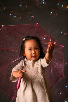 The small Korean girl with a umbrella and soap bubbles
