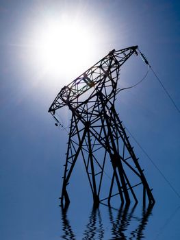 Electricity transformer and sun with water reflection