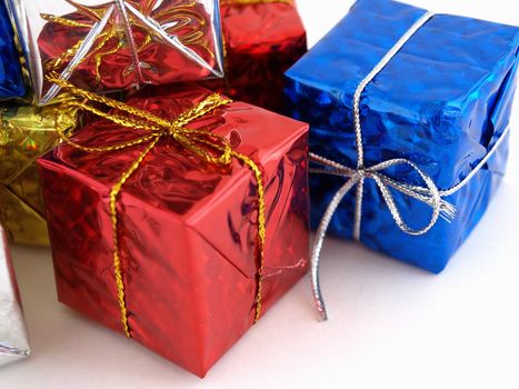 Colorful gift boxes in shiny wrapping paper isolated against a white background.