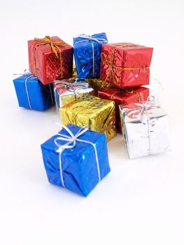 Colorful gift boxes in shiny wrapping paper isolated against a white background.