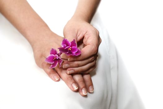 Hands of the bride on a background of a wedding dress
