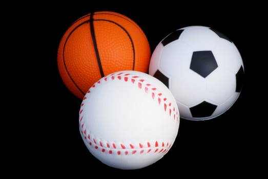 Baseball, basketball and football isolated on black background.