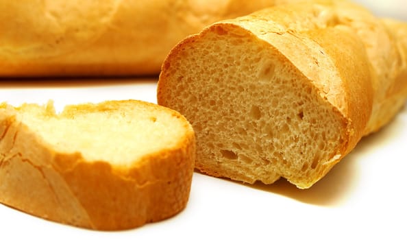 Fresh tasty bread which is cut on a part. Isolation on white. Shallow DOF.