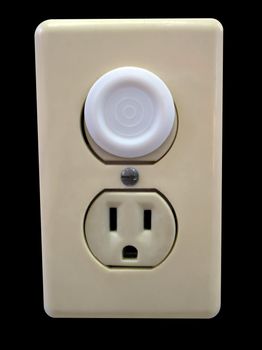 an electrical outlet complete with child safety plug - isolated over black