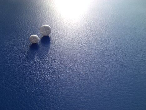 pharmaceutical research symbolized by pills on blue background