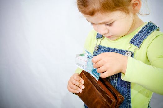 little girl with wallet and russian note in her hand