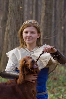 Portrait of the girl and irish setter in autumn forest.
