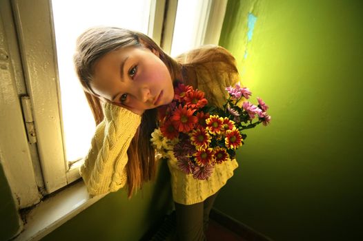 Portrait of the girl in a yellow sweater with chrysanthemums