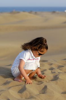 Young child is playing with sand