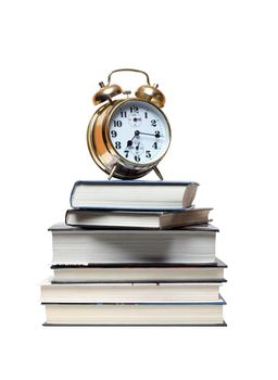 Alarm clock standing on stack of books. Isolated on white with clipping path