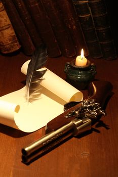 Ancient pistol near scroll and quill on wooden surface with lighting candle