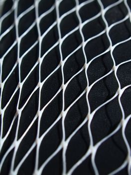 Closeup white net on black leather surface