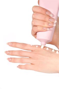 Woman hands applying cream from tube over white