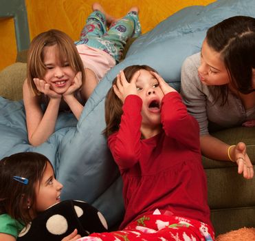 Surprised little girl with hands on head with friends at a sleepover