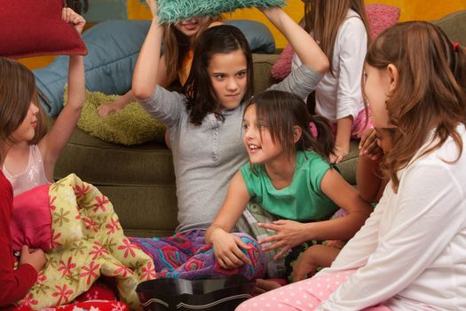 Little girl about to get whacked with a pillow at a sleepover