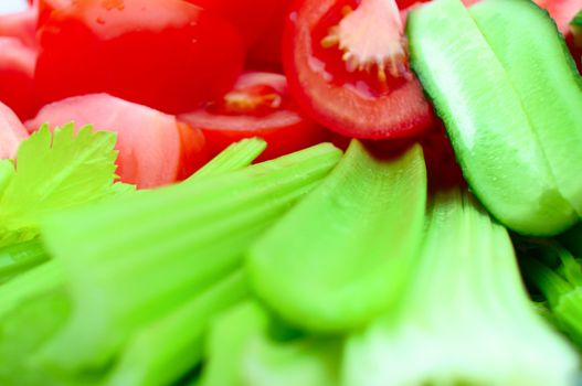 tomatoes, cucumbers, lettuce and condiments in the background