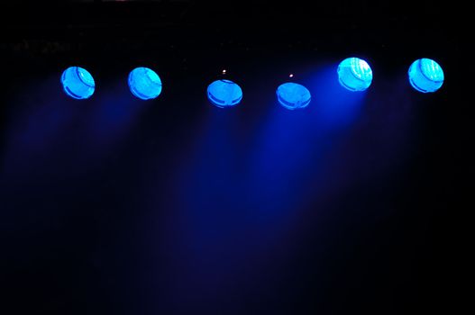 Lights and smoke. Row of blue spotlights from a stage.