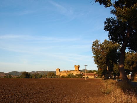Barren landscape in Tuscany with a castle.