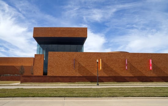 A long modern brick building with a blue sky