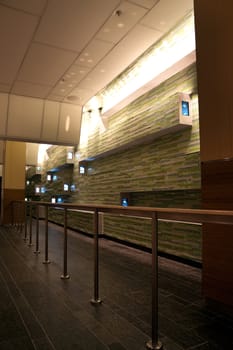 A empty waiting area with tiled wall and tvs