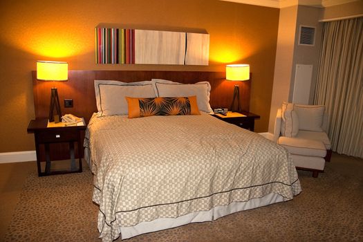 A hotel bedroom with nightstand and lights