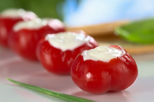 Small round hot red pepper filled with cream cheese (Very Shallow Depth of Field, Focus on the tip of the cream cheese filling in the first pepper)