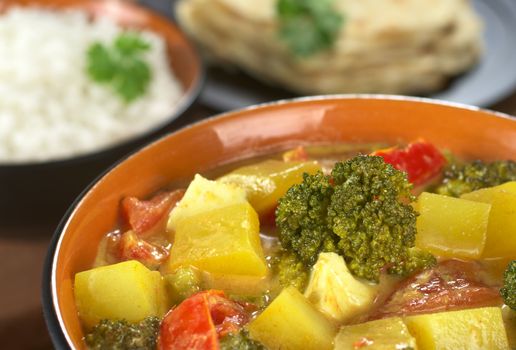 Delicious vegetarian Indian curry with rice and chapati flatbread in the back (Selective Focus, Focus on the broccoli)