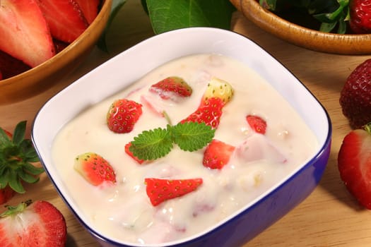 Strawberry yogurt with fresh strawberries on a wooden board